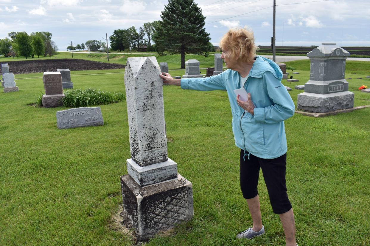 Barb Mallon feels a historic headstone that's recently been cleaned of dirt and lichen at Bethlehem Lutheran Church Cemetery in Slater. It's part of a larger project to clean and straighten the stones at the cemetery.