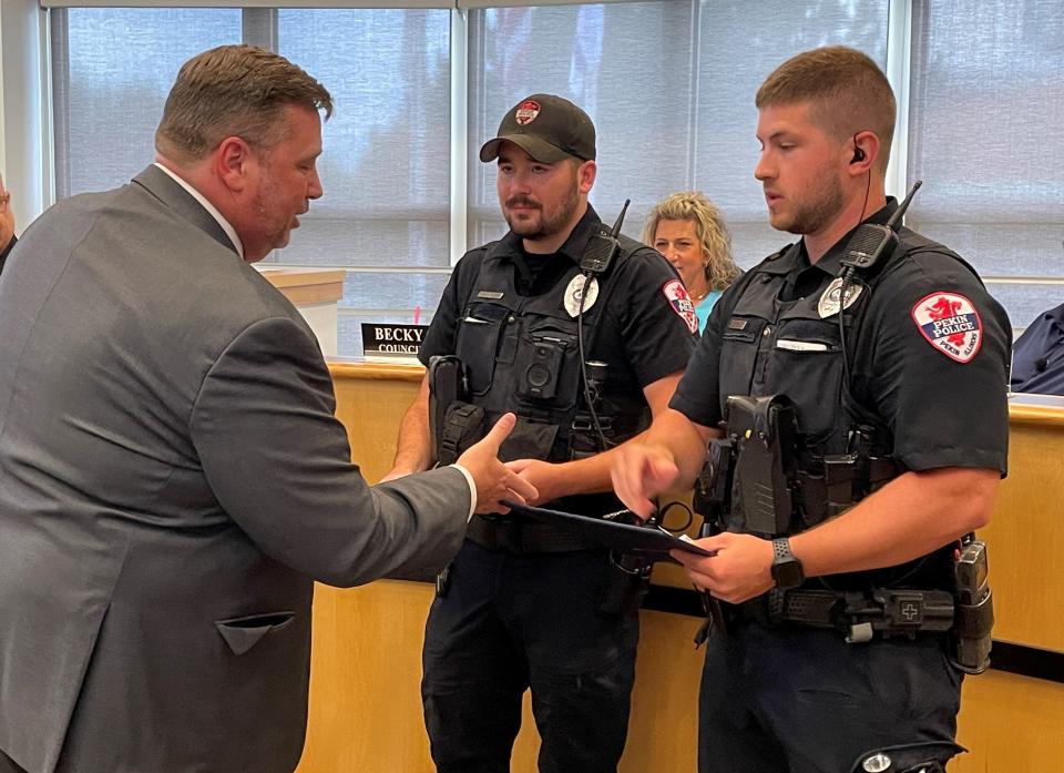 Illinois Association of Police Chiefs (IACP) Executive Director Kenny Winslow ((left) congratulates Pekin Police Officers Nick Appel (right) and Caleb Boyer (center) on being named 2023 IACP Award recipients.