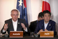 Australian Prime Minister Scott Morrison, left, speaks as Japan's Prime Minister Shinzo Abe listens during a signing ceremony for the Papua New Guinea Electrification Partnership at APEC Haus in Port Moresby, Papua New Guinea, Sunday, Nov. 18, 2018. (AP Photo/Mark Schiefelbein)