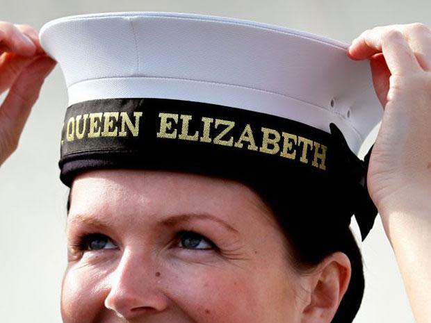 Royal Navy Leading Hand Claire Butler is presented with the first 'cap tally' for being the first crew member to board new aircraft carrier HMS Queen Elizabeth (PA)