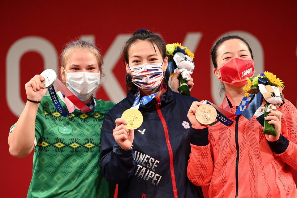 (From L to R) Turkmenistan's Polina Guryeva Silver medallist , Taiwan's Kuo Hsing-chun gold medallist and Japan's Mikiko Andoh bronze medallist stand on the podium for the victory ceremony of the women's 59kg weightlifting competition during the Tokyo 2020 Olympic Games at the Tokyo International Forum in Tokyo on July 27, 2021. (Photo by Vincenzo PINTO / AFP) (Photo by VINCENZO PINTO/AFP via Getty Images)