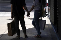 CORRECTS YEAR TO 2020 NOT 2019 Shoppers hold hands on Chicago's Magnificent Mile as they wait to cross the street on Tuesday, Aug. 11, 2020. (AP Photo/Charles Rex Arbogast)