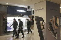 People pass by an advertisement of Samsung Electronics' Galaxy S21 Series smartphones at its shop in Seoul, South Korea, Thursday, Jan. 28, 2021.Samsung Electronics Co. said Thursday its operating profit for last quarter rose by more than 26% as it capped off a robust business year where its dual strength in parts and finished products allowed it to thrive amid the pandemic. (AP Photo/Ahn Young-joon)