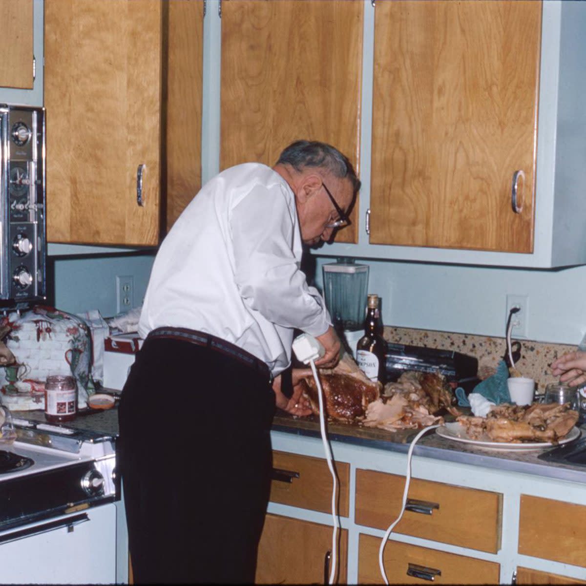 man carves turkey with electric turkey carver