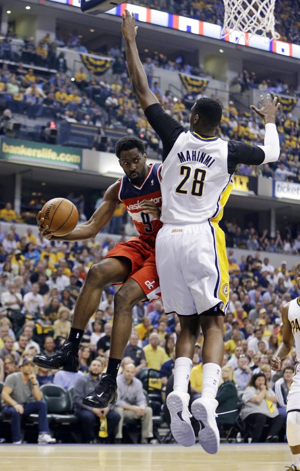 Washington Wizards forward Martell Webster, left, makes a pass around Indiana Pacers center Ian Mahinmi during the first half of game 2 of the Eastern Conference semifinal NBA basketball playoff series Wednesday, May 7, 2014, in Indianapolis. (AP Photo/Darron Cummings)