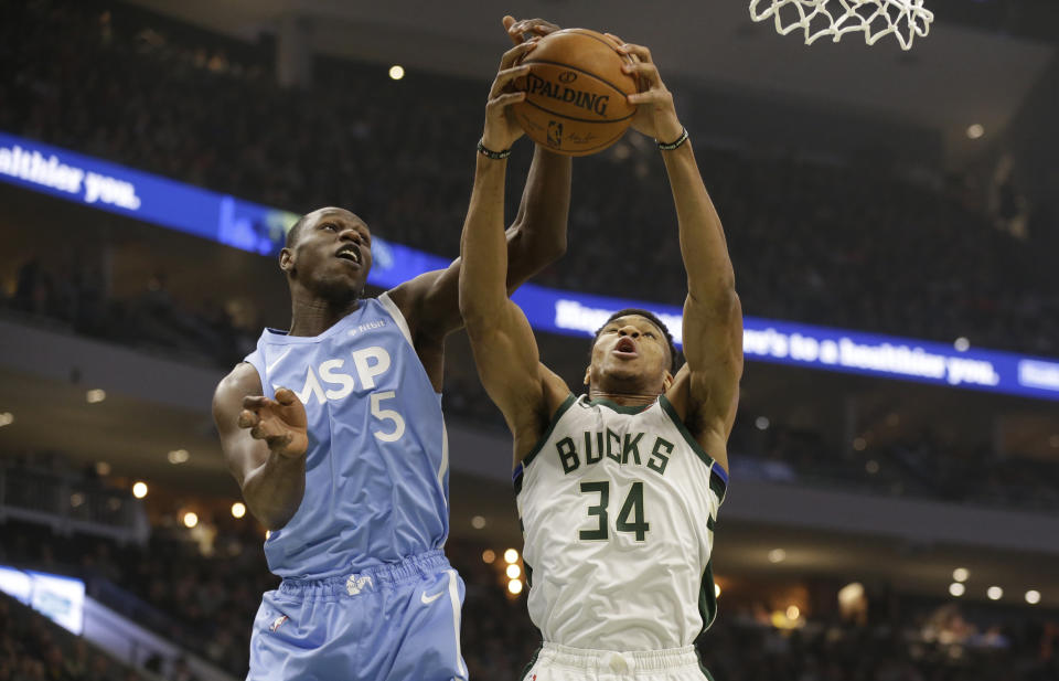 Milwaukee Bucks' Giannis Antetokounmpo (34) fights for a rebound against Minnesota Timberwolves' Gorgui Dieng during the first half of an NBA basketball game Wednesday, Jan. 1, 2020, in Milwaukee. (AP Photo/Jeffrey Phelps)