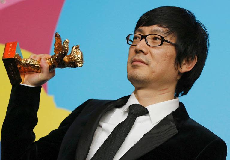 Director Diao Yinan holds the Golden Bear award for Best Film at the Berlin film festival on February 15, 2014