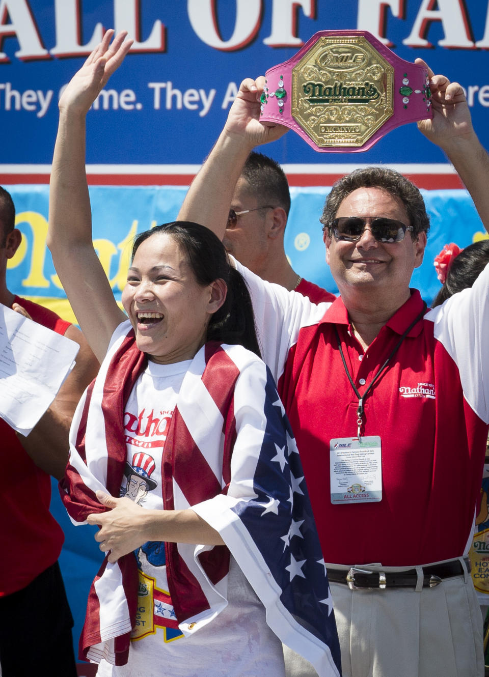 Sonya "The Black Widow" Thomas accepts her trophy after she wins Nathan's Famous Women's Hot Dog Eating World Championship, Wednesday, July 4, 2012, at Coney Island, in the Brooklyn borough of New York. Thomas beat her own record by gobbling down 45 hot dogs and buns in 10 minutes to win the women's competition at the annual Coney Island contest. (AP Photo/John Minchillo)