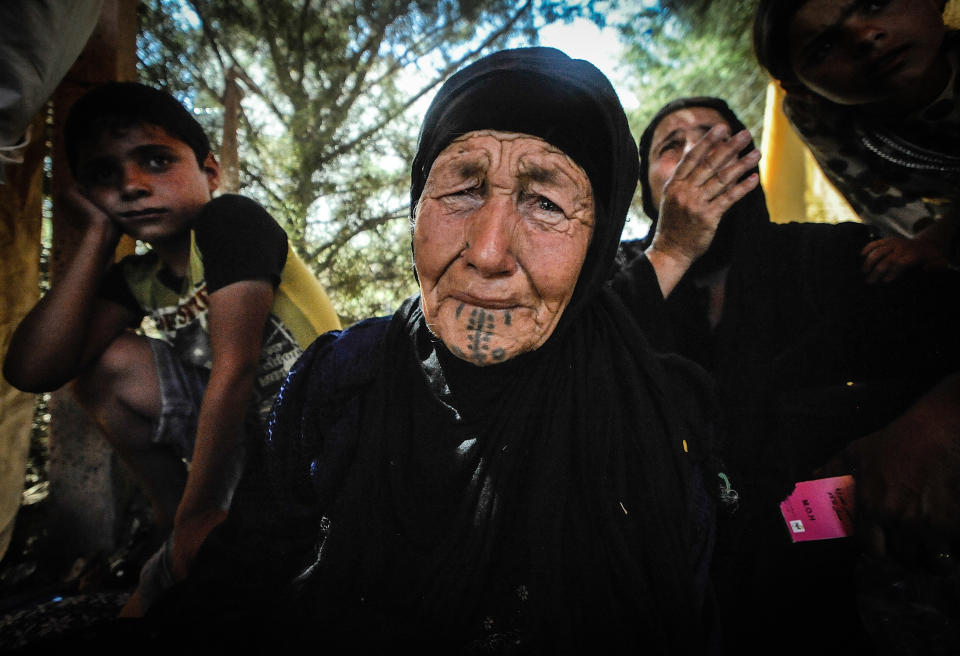 An 80 year old women becomes overwhelmed by the trauma of walking for 2 days from Qaraqosh is waiting to receive medical attention, in Irbil, Iraq, on August 10, 2014.