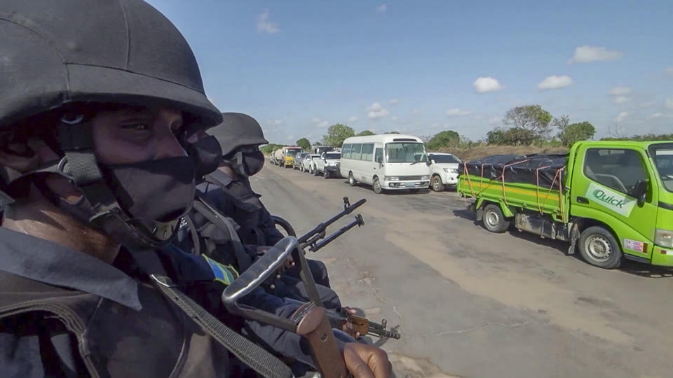 In this image made from video, Rwandan police patrol a road in Palma, Cabo Delgado province, Mozambique, Sunday Aug. 15, 2021. A new offensive by Mozambique's Islamic extremist rebels in Cabo Delgado has increased the number of displaced by 80,000 and undermines the government's claims of containing the insurgency. (AP Photo/Marc Hoogsteyns)