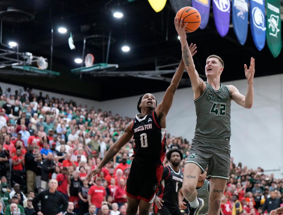 Stetson's Treyton Thompson (42) drives to the basket past Austin Peay's Demarcus Sharp (0) during the ASUN championship game at Edmunds Center in DeLand, Sunday, March 10, 2024.