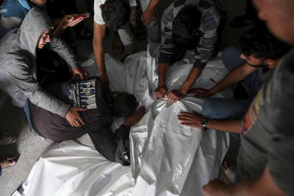 Palestinians mourn over the bodies of relatives killed in an Israeli airstrike, at a morgue in Rafah, Gaza Strip, Monday, May 27, 2024. Palestinian health workers said Israeli airstrikes Sunday killed at least 35 people sheltering in a tent camp for displaced people. Israel's army confirmed the strike and said it hit a Hamas installation and killed two senior Hamas militants. (AP Photo/Jehad Alshrafi)