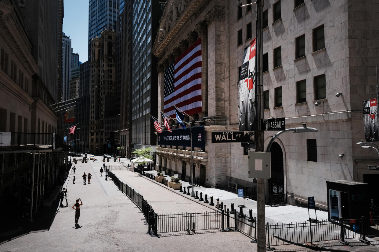 NEW YORK, NEW YORK - MAY 26: Television journalists and others gather across from the entrance to the New York Stock Exchange (NYSE) on the first day that traders are allowed back onto the historic floor of the exchange on May 26, 2020 in New York City. While only a small number of traders will be returning at this time, those that do will have to take temperature checks and wear face masks at all times while on the floor. The Dow rose over 600 points in morning trading as investors see economic activity in America picking up.  (Photo by Spencer Platt/Getty Images)