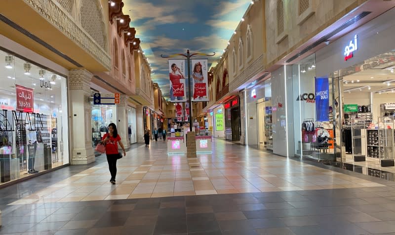 FILE PHOTO: A woman walks in an almost empty mall amid the outbreak of coronavirus disease (COVID-19), in Dubai