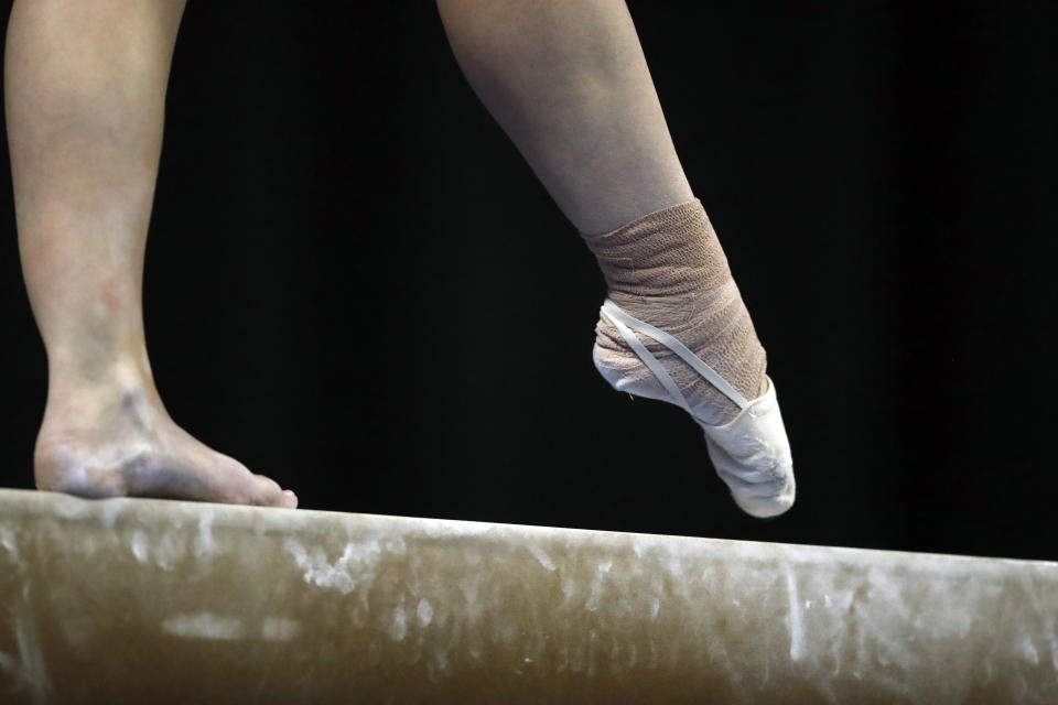 FILE - An athlete competes on the balance beam during the NCAA college women's gymnastics championships, Friday, April 20, 2018, in St. Louis. The Supreme Court's decision to overturn Roe v. Wade has added another complicated layer for college coaches to navigate. And, for some coaches, the constantly shifting landscape is making their profession more demanding than ever. (AP Photo/Jeff Roberson, File)