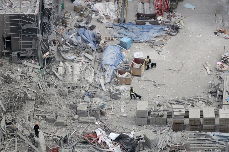 Rescuers search for workers who went missing in an apartment construction accident in Gwangju, South Korea, Thursday, Jan. 13, 2022. South Korean rescue workers at a collapsed construction site in the southern city of Gwangju located a man amid a pile of debris and broken concrete on their third day searching for six missing construction workers, officials said Thursday. (Chung Hoe-sung /Yonhap via AP)