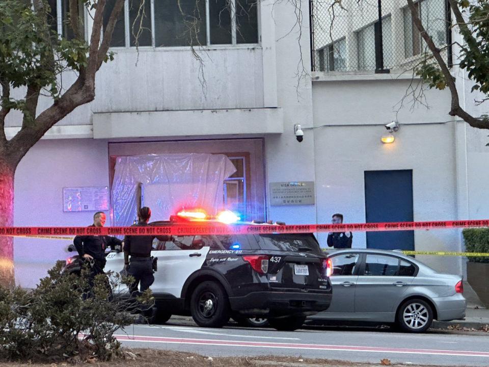 舊金山警方封鎖中領館周邊道路。圖中可看到簽證處被撞壞的門用塑膠布擋住。(記者李怡╱攝影)