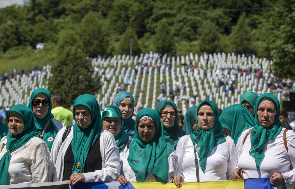 Women wait for the funeral ceremony in Potocari near Srebrenica, Bosnia, Thursday, July 11, 2019. The remains of 33 victims of the Srebrenica massacre will be buried 24 years after Serb troops overran the eastern Bosnian Muslim enclave of Srebrenica and executed some 8,000 Muslim men and boys, which international courts have labeled as an act of genocide. (AP Photo/Darko Bandic)