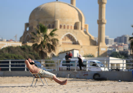 FILE PHOTO: A man sunbathes at a beach in the port city of Sidon, southern Lebanon, January 17, 2017. REUTERS/Ali Hashisho/File Photo