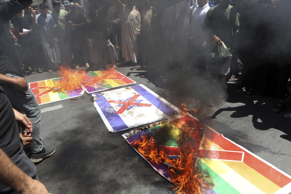 Supporters of Shiite Muslim leader Moqtada Sadr burn a rainbow flag, in response to the burning of a copy of the Quran in Sweden, during open-air Friday prayers in Basra, Iraq, Friday, June 30, 2023. (AP Photo/ Nabil al-Jurani)