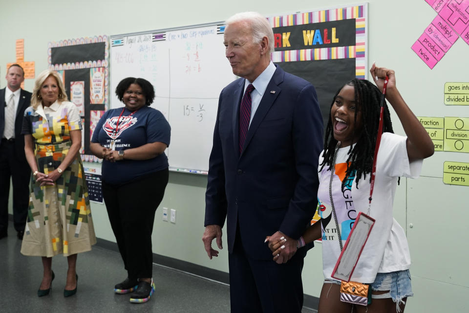 President Joe Biden holds hands with a student at Eliot-Hine Middle School on Monday, Aug. 28, 2023, in Washington as he visits the school, located east of the U.S. Capitol, to mark the District of Columbia's first day of school for the 2023-24 year. First lady Jill Biden looks on at left. (AP Photo/Manuel Balce Ceneta)