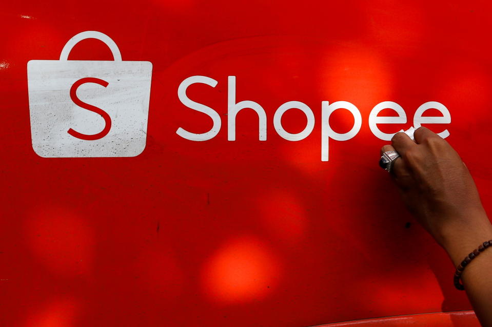 A worker wipes the door of a car with the sign of Shopee, an Indonesian e-commerce platform, in Jakarta, Indonesia, February 5, 2021. REUTERS/Ajeng Dinar Ulfiana