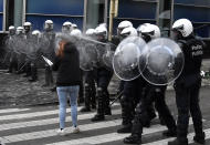 A police officer sprays pepper spray during a protest against coronavirus measures in Brussels, Belgium, Sunday, Dec. 5, 2021. Hundreds of people marched through central Brussels on Sunday to protest tightened COVID-19 restrictions imposed by the Belgian government to counter the latest spike in coronavirus cases. (AP Photo/Geert Vanden Wijngaert)