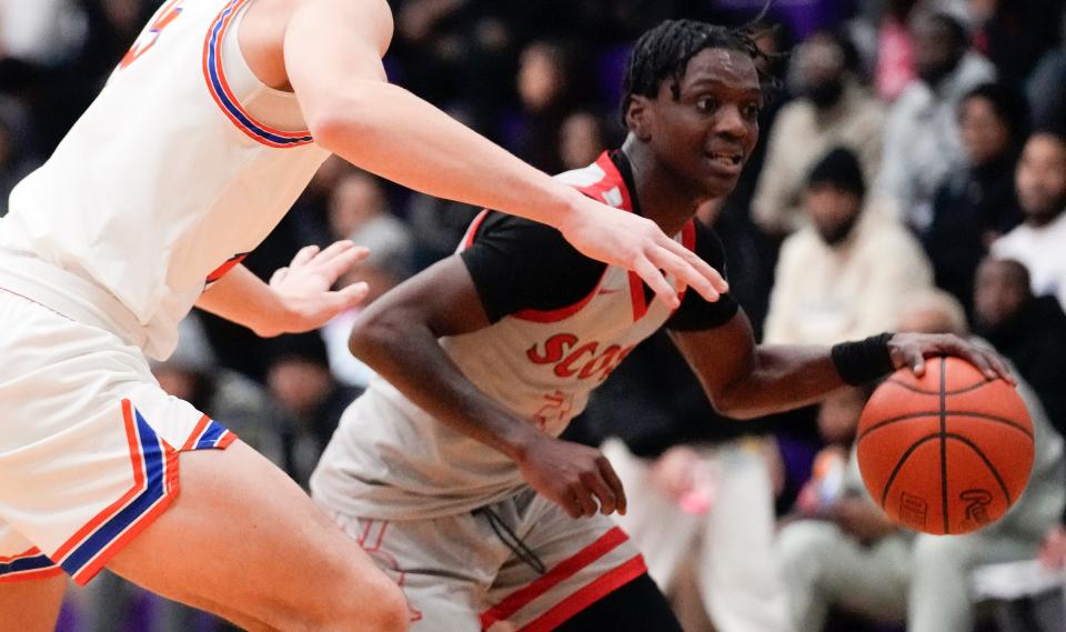 Walnut Ridge senior point guard Dominique Aekins dribbles around Olentangy Orange's Devin Brown on Jan. 20.