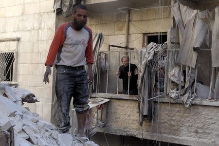 Residents inspect damage after an air strike on the rebel held al-Saliheen district in Aleppo, Syria, March 11, 2016. REUTERS/Abdalrhman Ismail