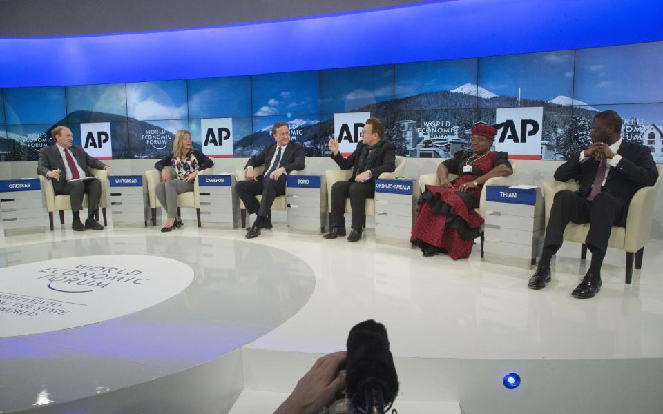 AP Senior Managing Editor Michael Oreskes, left, moderates a discussion with, from left, Save the Children International CEO Jasmine Whitbread, British Prime Minister David Cameron, rock star Bono, Nigerian Finance Minister Ngozi Okonjo-Iweala and Tidjane Thiam, Prudential group chief executive during a panel discussion "The Post-2015 Goals: Inspiring a New Generation to Act", the fifth annual Associated Press debate, at the World Economic Forum in Davos, Switzerland, Friday, Jan. 24, 2014. (AP Photo/Michel Euler)