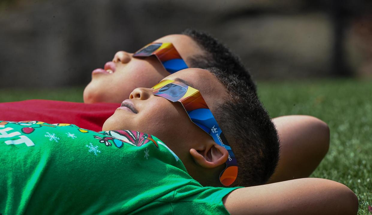 Ayden Day, and Jayde Day of Augusta, Georgia, check out the sun with proper solar eclipse glasses with their father Dion Day at Falls Park 12:45 pm, about an hour before the start of a solar eclipse with viewers in Greenville, S.C. Monday, April 8, 2024. The peak time is estimated 3:08 p.m.