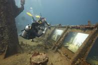 Un par de buzos recorre la exhibición "The Sinking World" en el naufragado barco "SS Stavornikita", en las aguas de Barbados, en el mar Caribe.