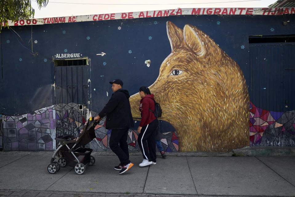 In this March 5, 2019, image, Juan Carlos Perla and Ruth Aracely Monroy leave a shelter for migrants in Tijuana, Mexico with their sons. After fleeing El Salvador and requesting asylum in the United States, the family was returned to Tijuana to wait for their hearing in San Diego. They were one of the first families to contend with a new policy that makes asylum seekers stay in Mexico while their cases wind through U.S. immigration courts. (AP Photo/Gregory Bull)