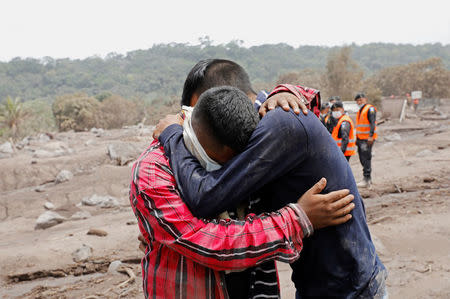 Brian Rivera, who lost 13 members of his family during the eruption of the Fuego volcano, is comforted, near debris of his home at San Miguel Los Lotes, Escuintla, Guatemala 7 June, 2018. REUTERS/Carlos Jasso