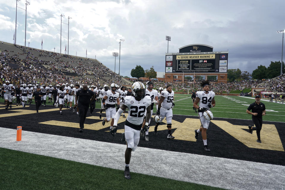 Vanderbilt players and coaches leave the field after a weather postponement during the first half of an NCAA college football game in Winston-Salem, N.C., Saturday, Sept. 9, 2023. (AP Photo/Chuck Burton)