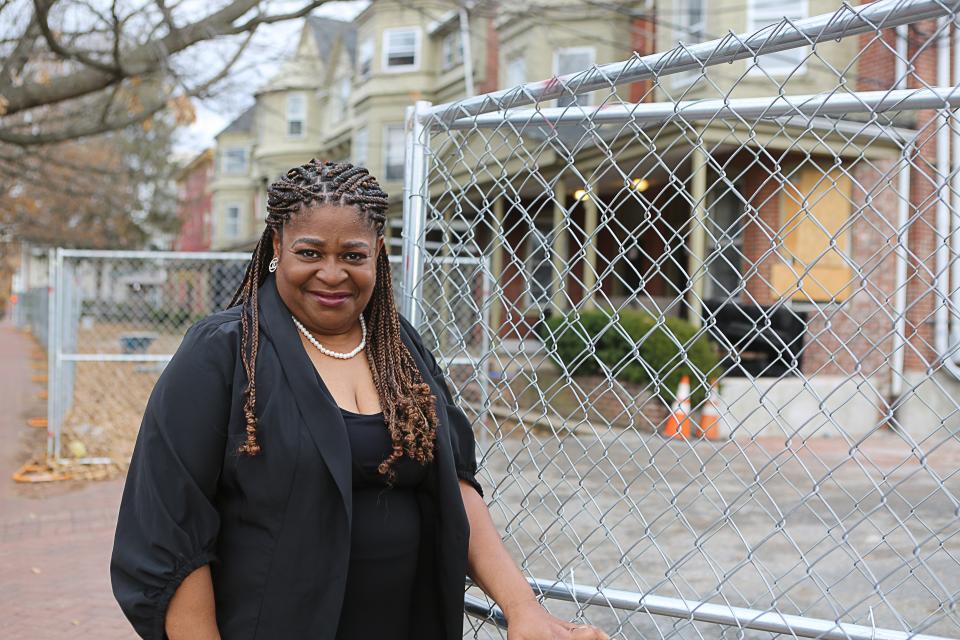 Stacey Henry stands in front of a series of condemned properties in the 800 block of North Adams Street in Wilmington. Henry has worked for months trying to help dozens of families living in the properties find housing, supplies and other services.