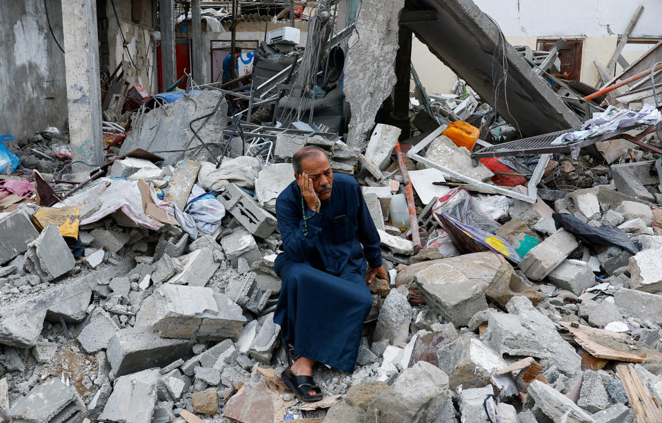 A man sits on the rubble of a building in the southern Gaza Strip on Monday. (Ibraheem Abu Mustafa/Reuters)