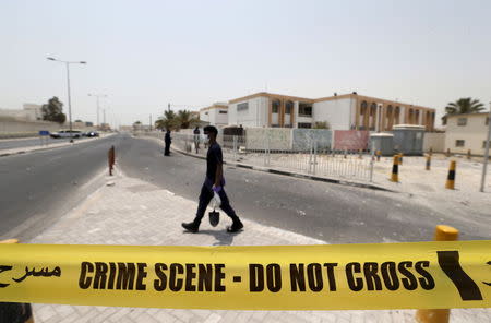 An explosives specialist police officer carries a bag of samples collected after a bomb blast in the village of Sitra, south of Manama, Bahrain, July 28, 2015. REUTERS/Hamad I Mohammed