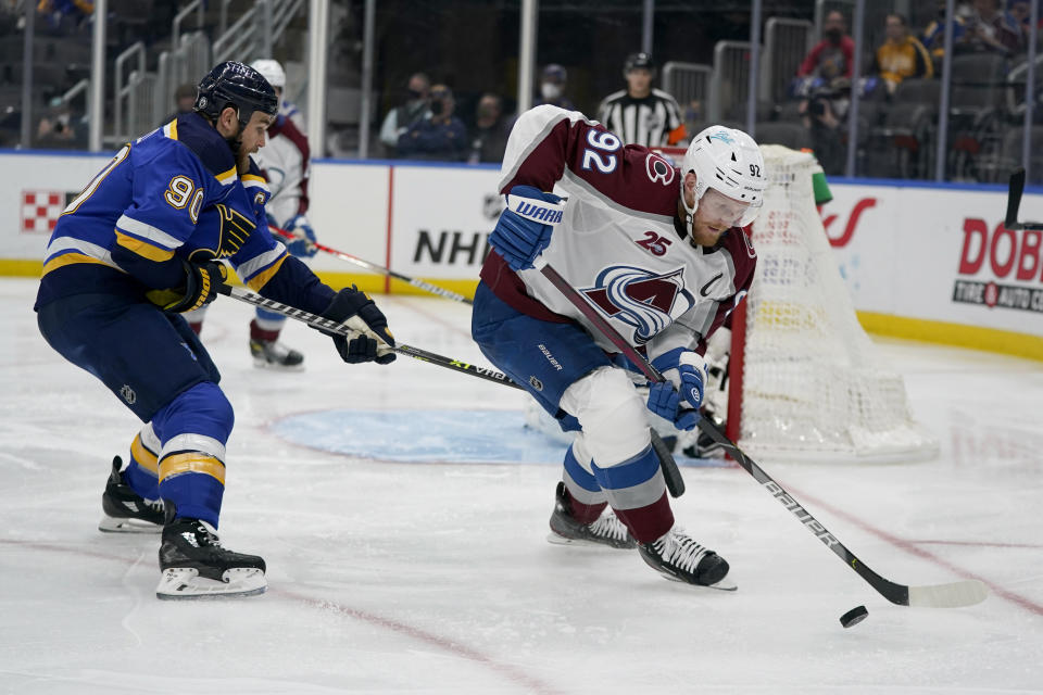 Colorado Avalanche's Gabriel Landeskog (92) handles the puck as St. Louis Blues' Ryan O'Reilly (90) defends during the second period in Game 4 of an NHL hockey Stanley Cup first-round playoff series Sunday, May 23, 2021, in St. Louis. (AP Photo/Jeff Roberson)