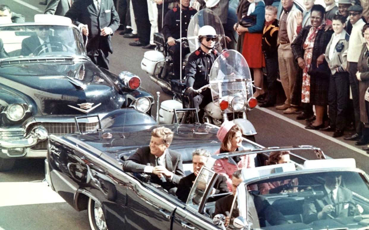 John F. Kennedy is photographed moments before he was fatally shot while riding in a presidential motorcade in Dallas