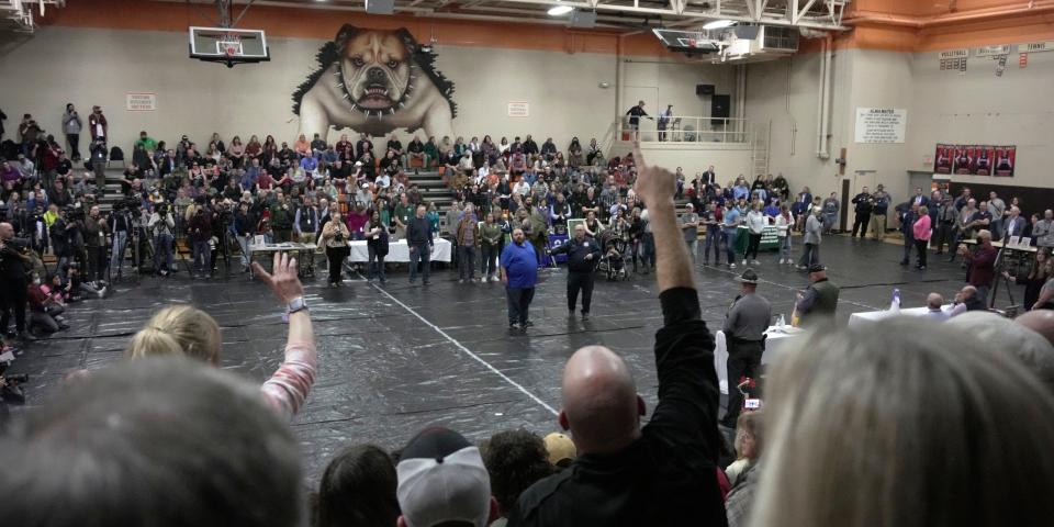 residents on bleachers in local gym for meeting