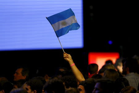 A supporter of Argentinean presidential candidate Mauricio Macri waves an Argentinian flag as they gather at their headquarter in Buenos Aires, November 22, 2015. Two exit polls showed opposition challenger Mauricio Macri appeared to have won Argentina's presidential election on Sunday against leftist ruling party candidate Daniel Scioli. Loud cheers erupted in Macri's campaign headquarters where party insiders estimated the centre-right mayor of Buenos Aires had won by a margin of 5 to 8 percentage points. If the result is confirmed, it will be the first time in more than a decade that the opposition has wrested the presidency from the populist Peronists. REUTERS/Ivan Alvarado