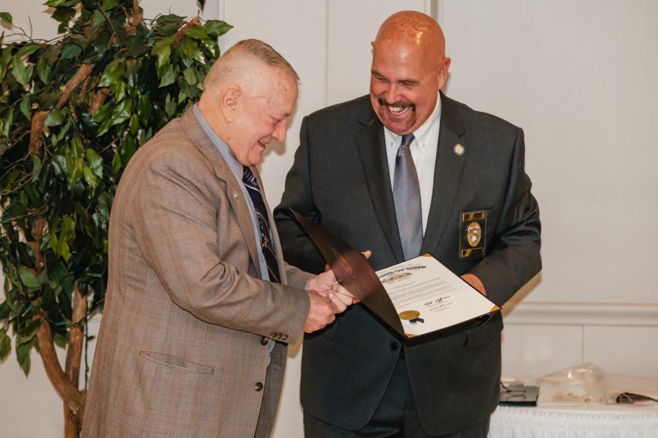 Retired law enforcement officer Dennis Vitt receives a commendation from Robert Everett during the Fraternal Order of Police Tuscora Lodge event honoring 50-year members on Wednesday.