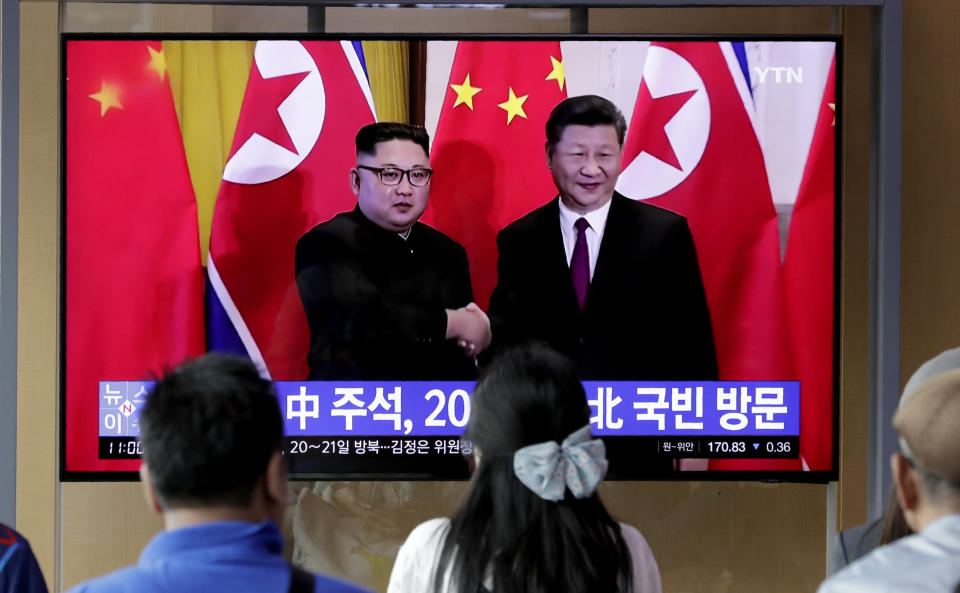 In this June 18, 2019 photo, people watch a TV news program reporting about Chinese President Xi Jinping's state visit to North Korea with a file footage of Chinese President Xi Jinping and North Korean leader Kim Jong Un, at the Seoul Railway Station in Seoul, South Korea. From nukes to huge food aid shipments to a shared skepticism about the United States, Xi and Kim will have a long list of topics to discuss when Xi heads north Thursday, June 20.(AP Photo/Lee Jin-man)