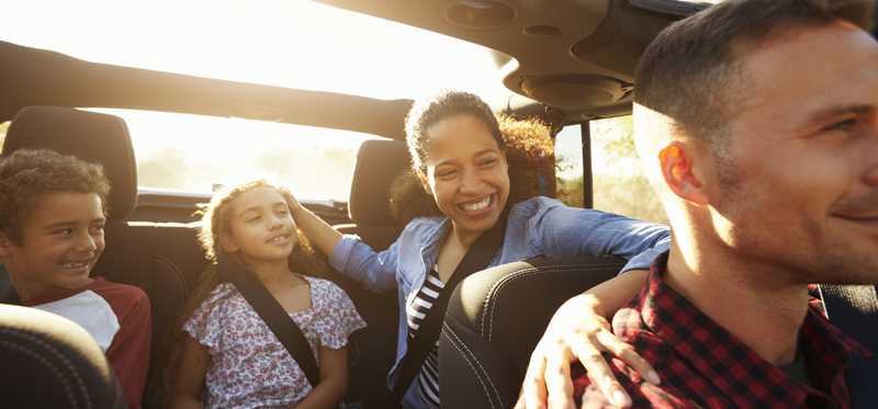 Happy family in a car with sunroof open