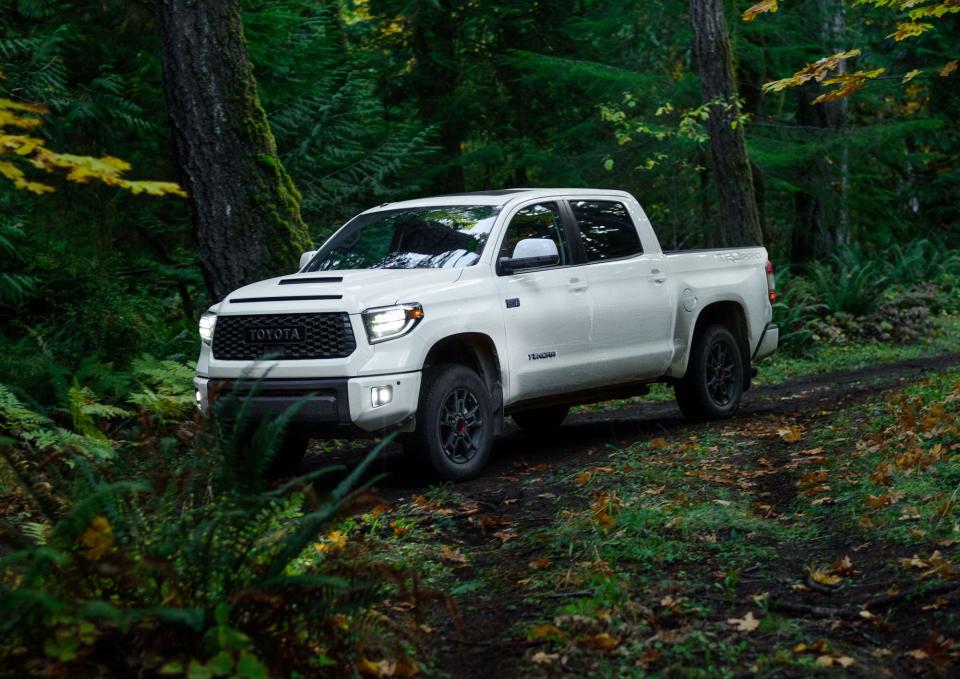 A white 2020 Toyota Tundra truck in a dark-green forest.