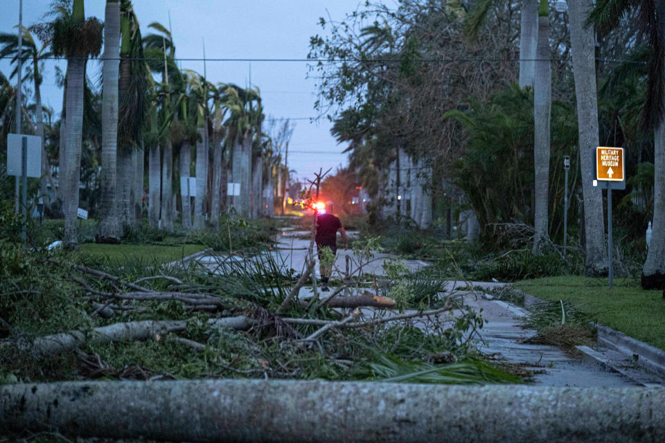 A man walks through debris on a street in the aftermath of Hurricane Ian in Punta Gorda on Sept. 29, 2022.