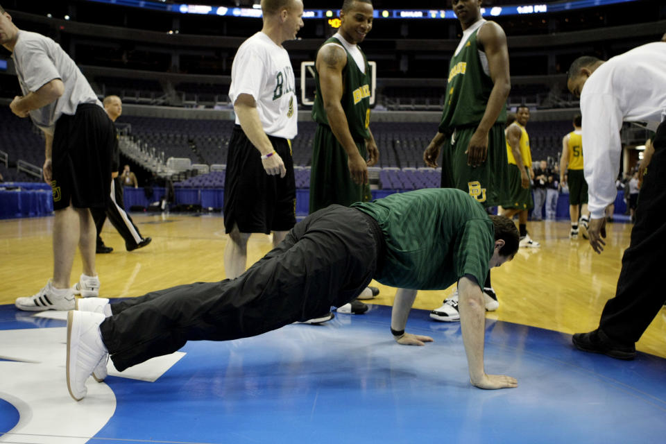 Baylor head coach Scott Drew does five push-ups at center court after a successful team practice at the Verizon Center in Washington, Wednesday, March 19, 2008 in preparation for the NCAA first round West Regional basketball game. Looking on are Baylor players Curtis Jerrells, center, and Fred Ellis, right. (AP Photos/Pablo Martinez Monsivais)