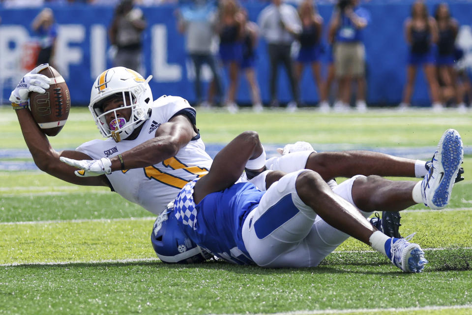 Chattanooga wide receiver Tyron Arnett (11) gets tackled by a Kentucky defender during the second half of a NCAA college football game in Lexington, Ky., Saturday, Sept. 18, 2021. (AP Photo/Michael Clubb)