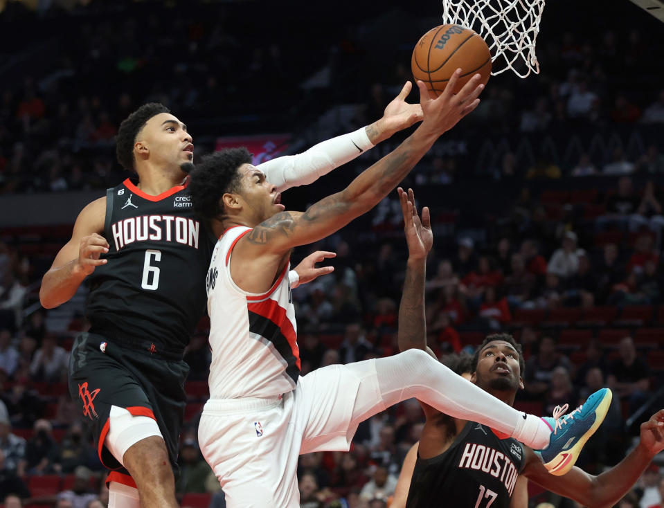 Portland Trail Blazers guard Anfernee Simons, right, goes in for a layup as Houston Rockets forward Kenyon Martin Jr., left, defends during the second half of an NBA basketball game in Portland, Ore., Friday, Oct. 28, 2022. (AP Photo/Steve Dipaola)